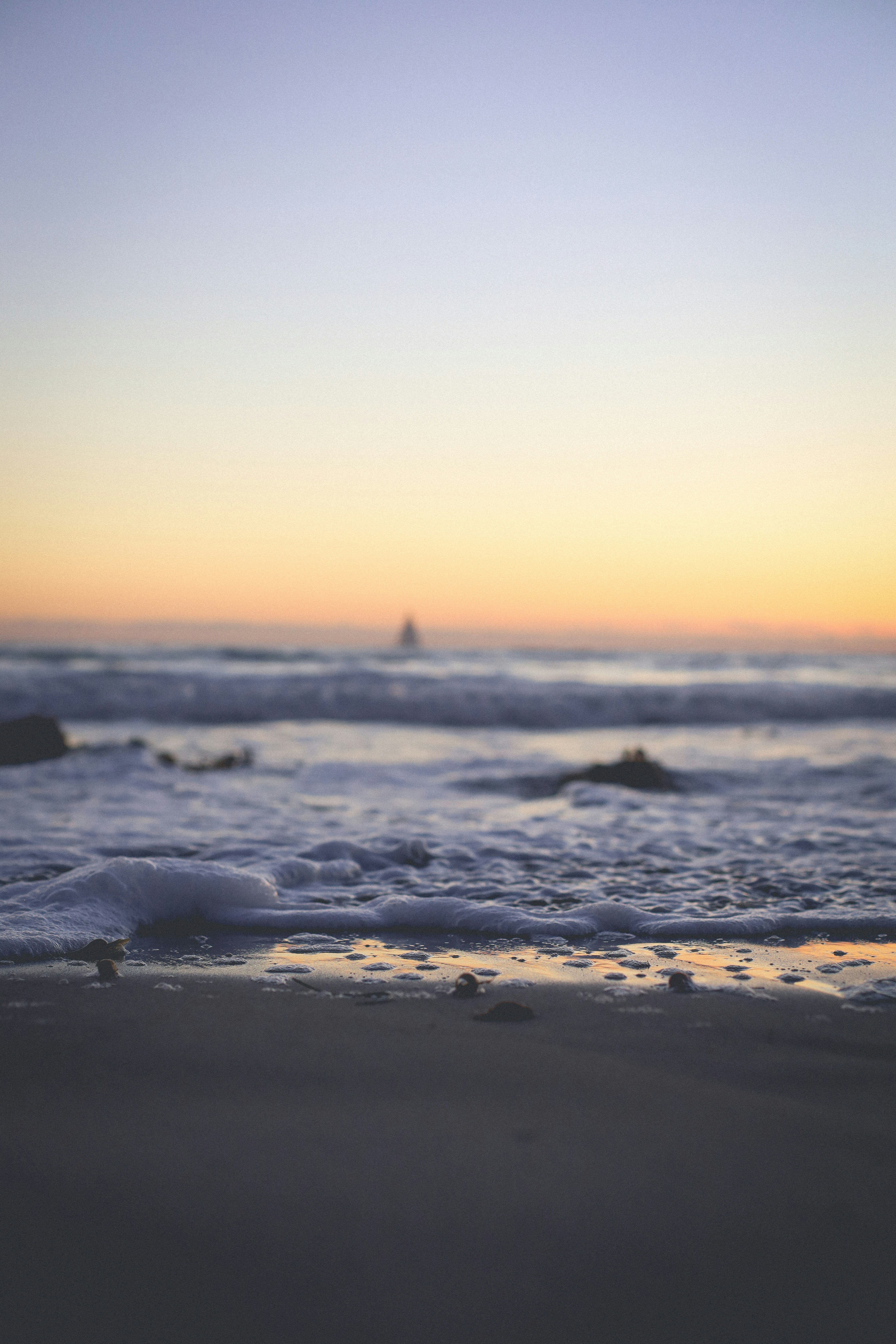 sea waves crashing on shore during sunset